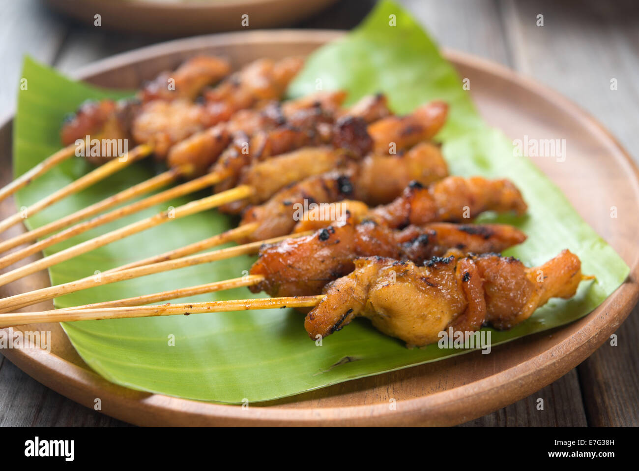 Malaysian Chicken Satay am Esstisch aus Holz, eines berühmten lokalen Gerichte hautnah. Stockfoto
