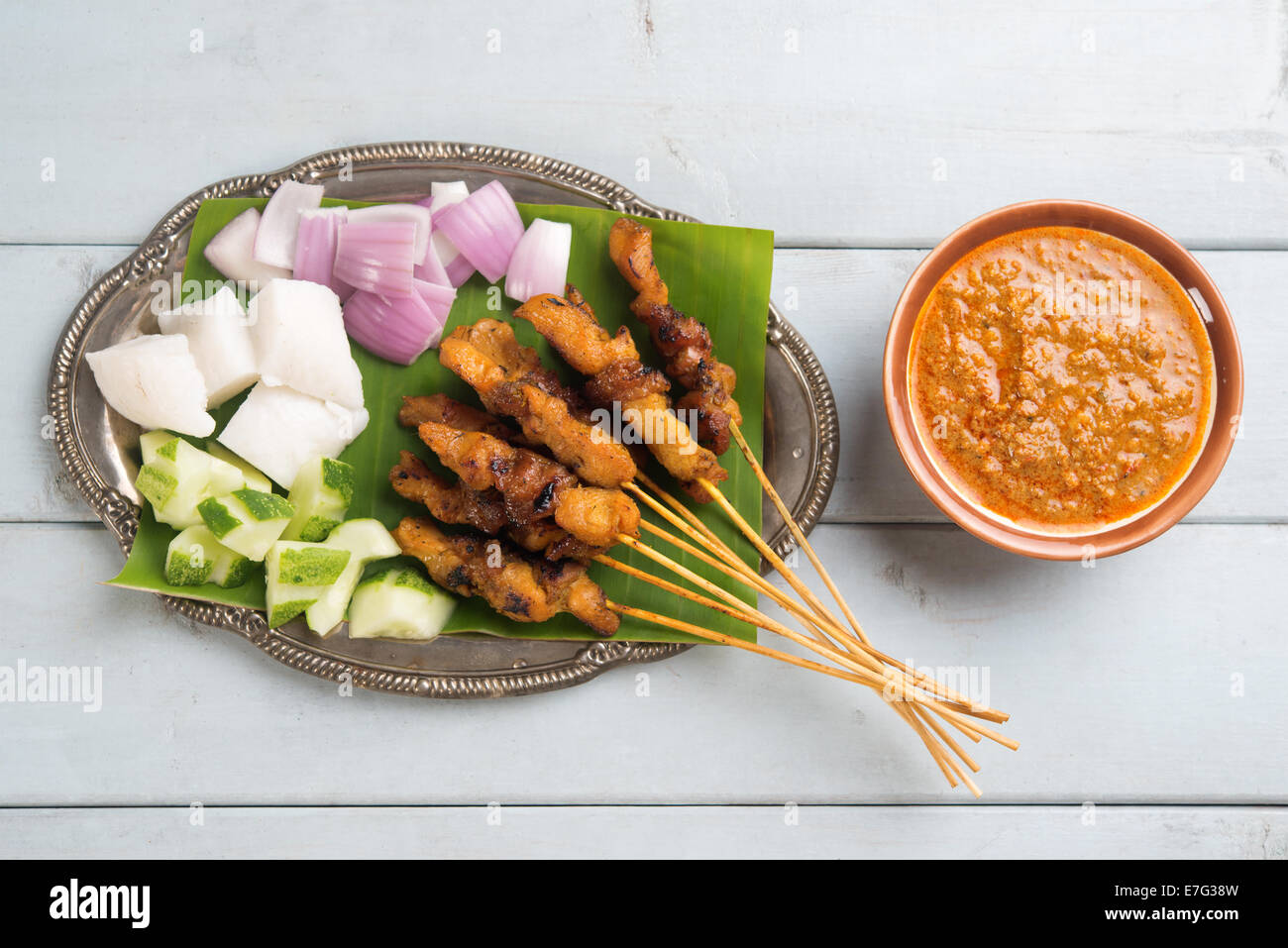 Frische Hähnchen-Satay am Esstisch aus Holz, einer der berühmten malaysische Gerichte. Stockfoto