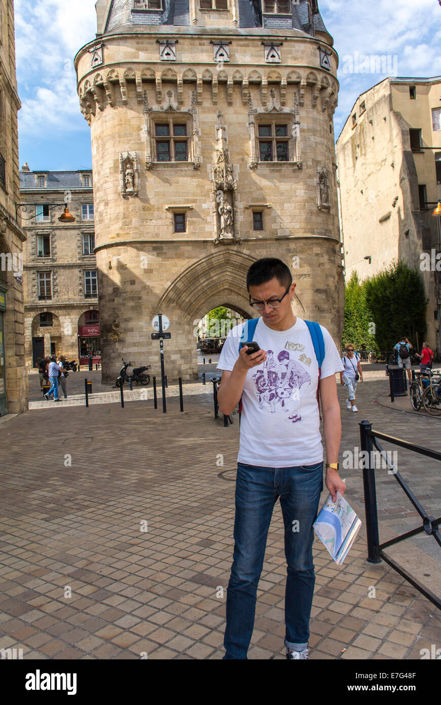 Bordeaux, Frankreich, Europa Chinesischer Tourist besucht französische Stadt, Straßenszenen, Touristen Sightseeing, französische Denkmäler, Kirche Saint Remi (Chinesischer Mann wird veröffentlicht), die auf das iphone schaut Stockfoto