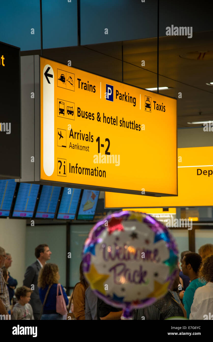 Menschen mit willkommen Ballon am Schiphol Flughafen in der Ankunftshalle warten Stockfoto