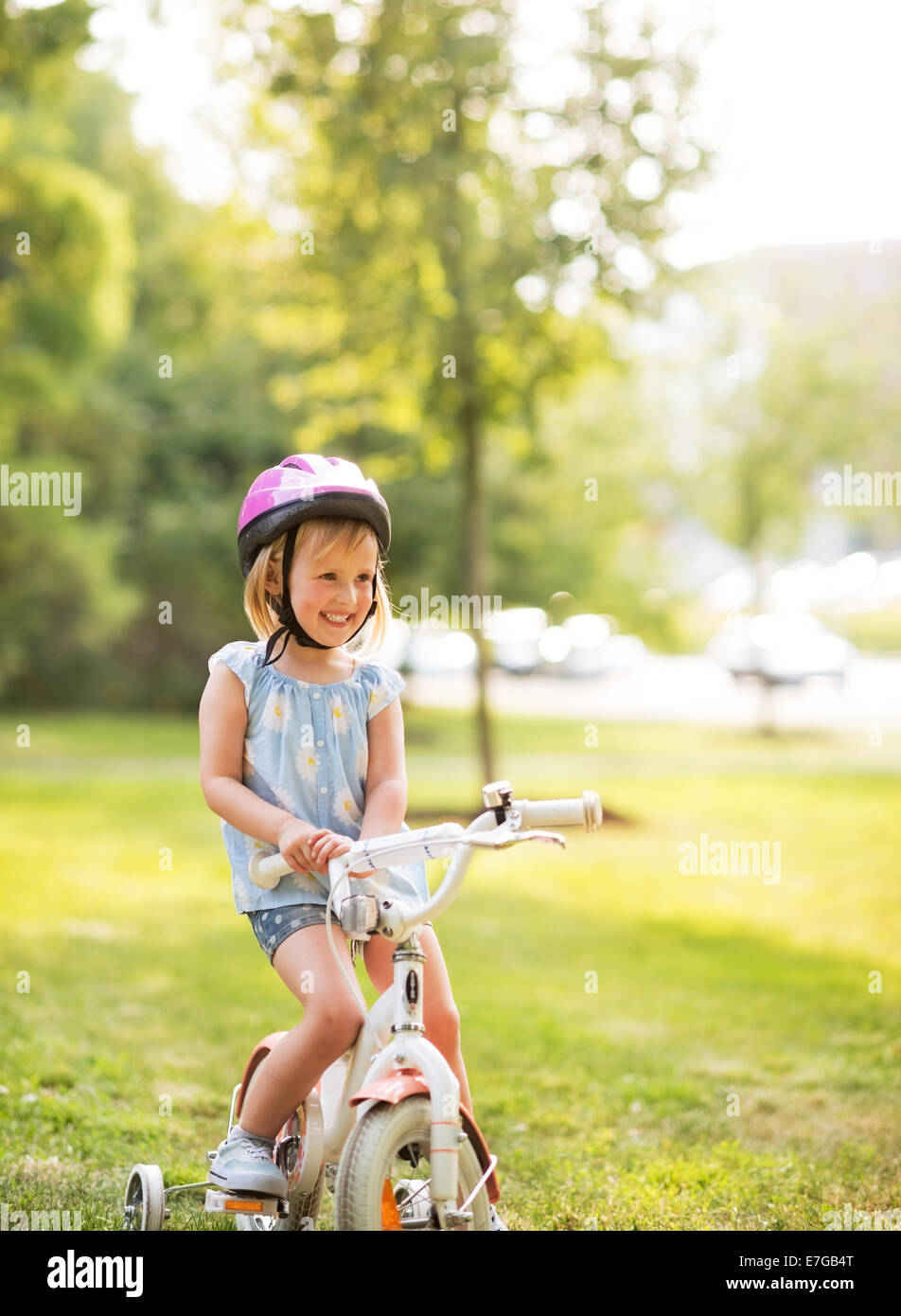 Porträt von lächelndes Babymädchen mit dem Fahrrad im park Stockfoto