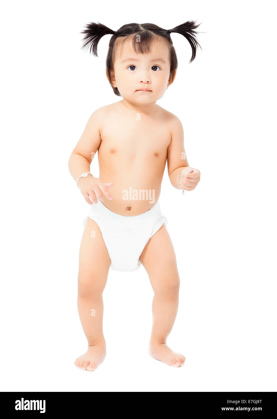 niedliche Babymädchen in einem Windel steht. isoliert auf weißem Hintergrund Stockfoto