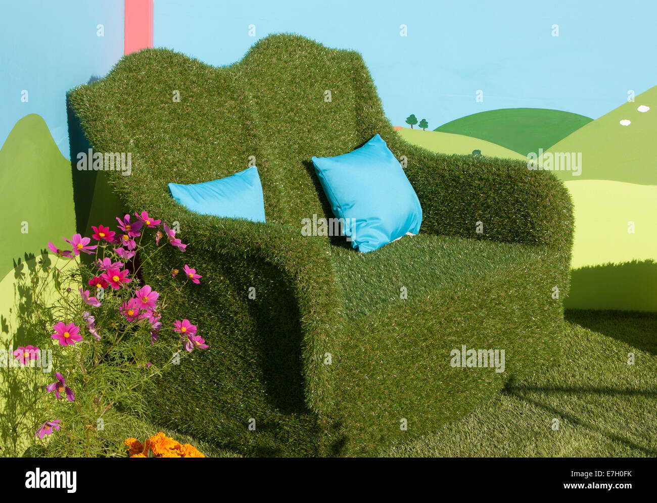 -Making Sense - Kunstrasen bedeckt Gartensofa mit Kosmos und Ringelblume Pflanzen wachsen in Kinder Stockfoto