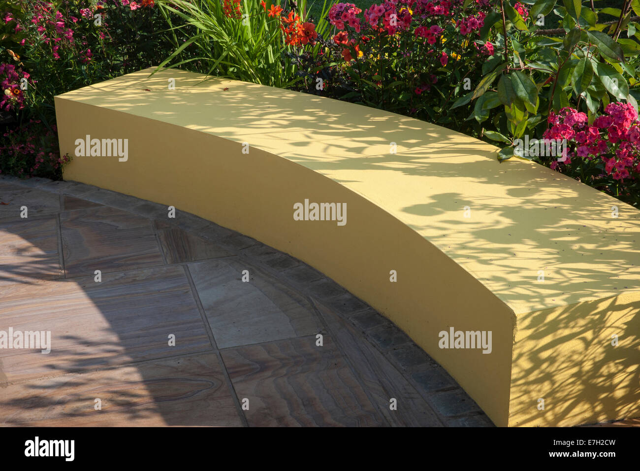 Garten - sicher vor Schaden - gelbe Holz Gartenbank - Designer - Andrew Walker - Sponsor AJ Bell Stockfoto