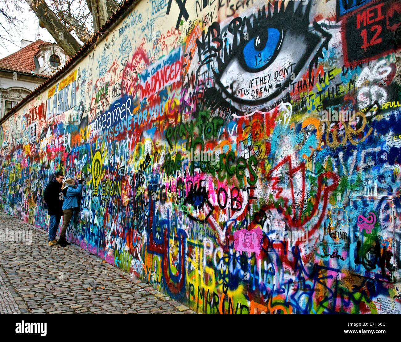 Ein junges Paar die Lennon-Mauer, Prag, Tschechische Republik ihre Nachricht hinzufügen Stockfoto