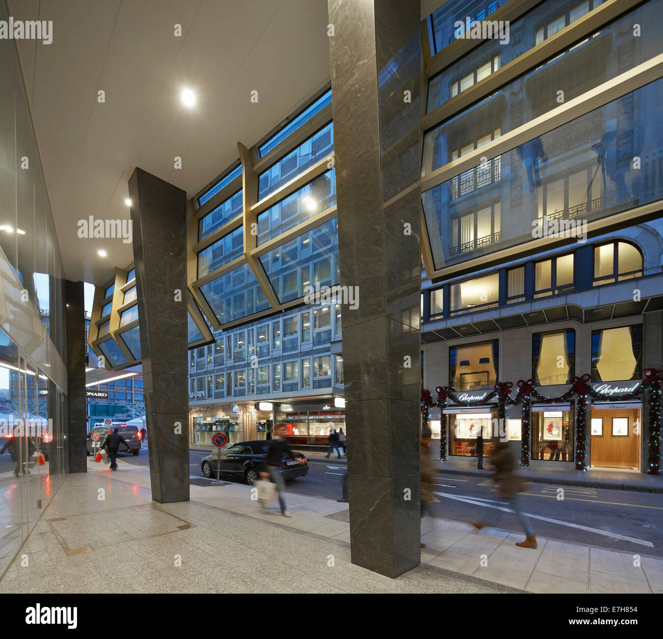 42 rue du Rhône in Genf, Schweiz. Architekt: Sheppard Robson, 2012. Abenddämmerung Blick vom Erdgeschoss Baldachin in Richtung Straße. Stockfoto
