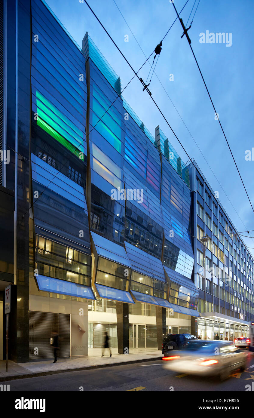 42 rue du Rhône in Genf, Schweiz. Architekt: Sheppard Robson, 2012. Gebäude-Fassade und Straße in der Abenddämmerung. Stockfoto