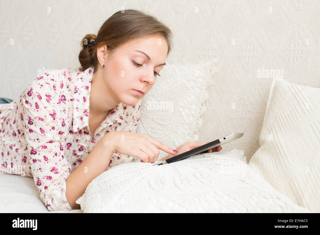 Porträt der Frau 20-25 Jahre alt mit mobilen Gerät in ihren Händen liegen Stockfoto