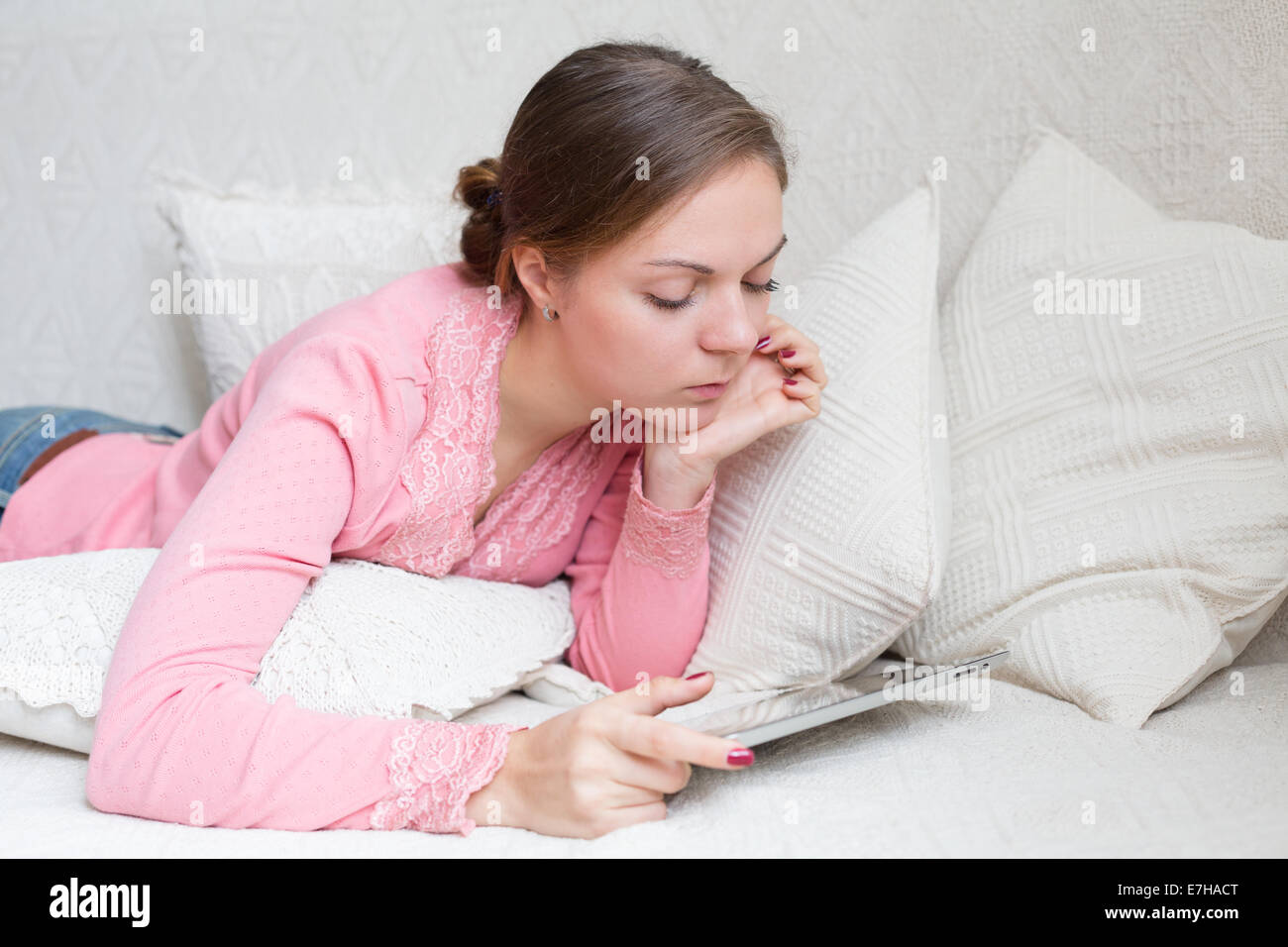 Porträt der Frau 20-25 Jahre alt mit mobilen Gerät in ihren Händen liegen Stockfoto