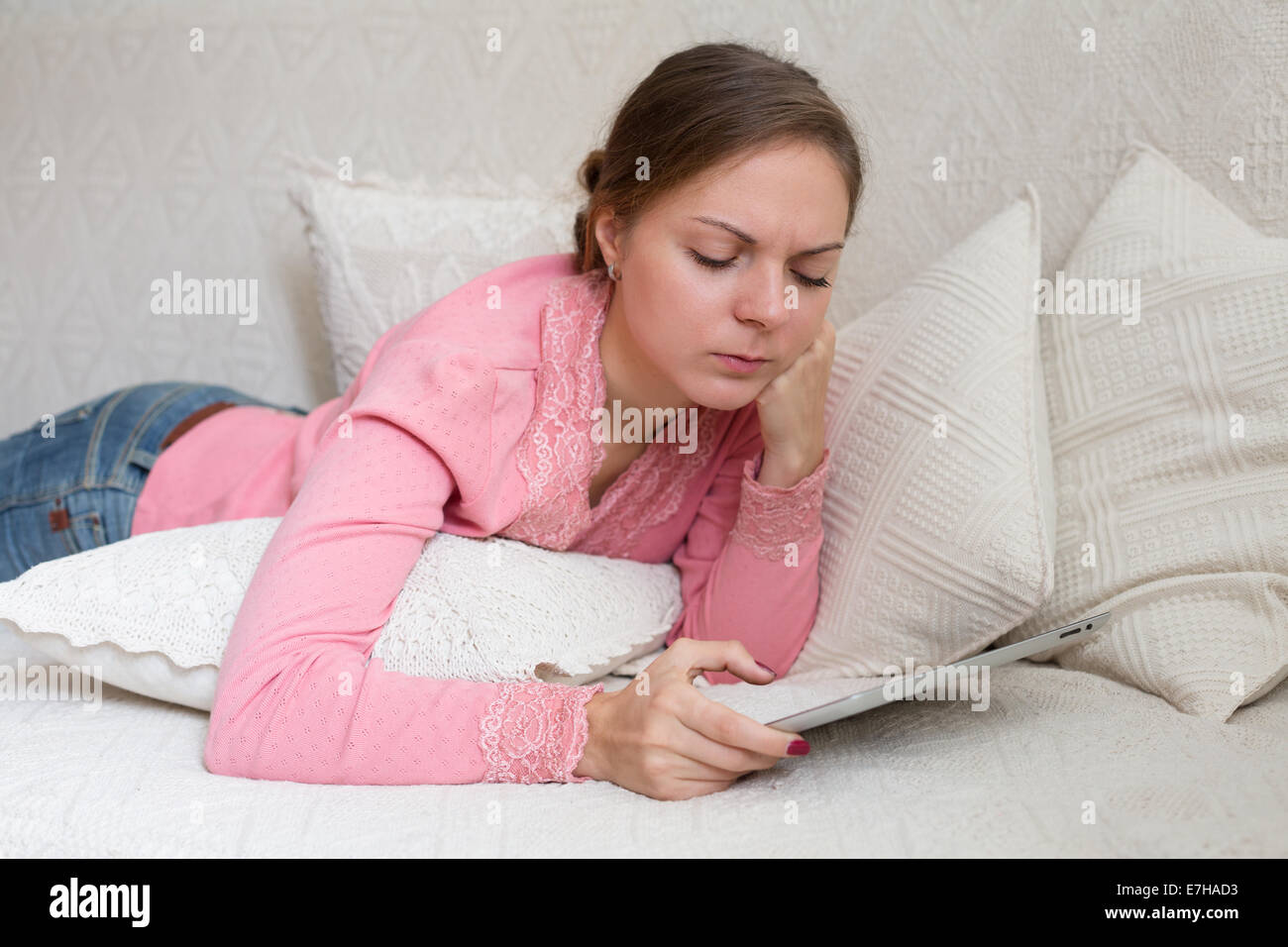 Porträt der Frau 20-25 Jahre alt mit mobilen Gerät in ihren Händen liegen Stockfoto