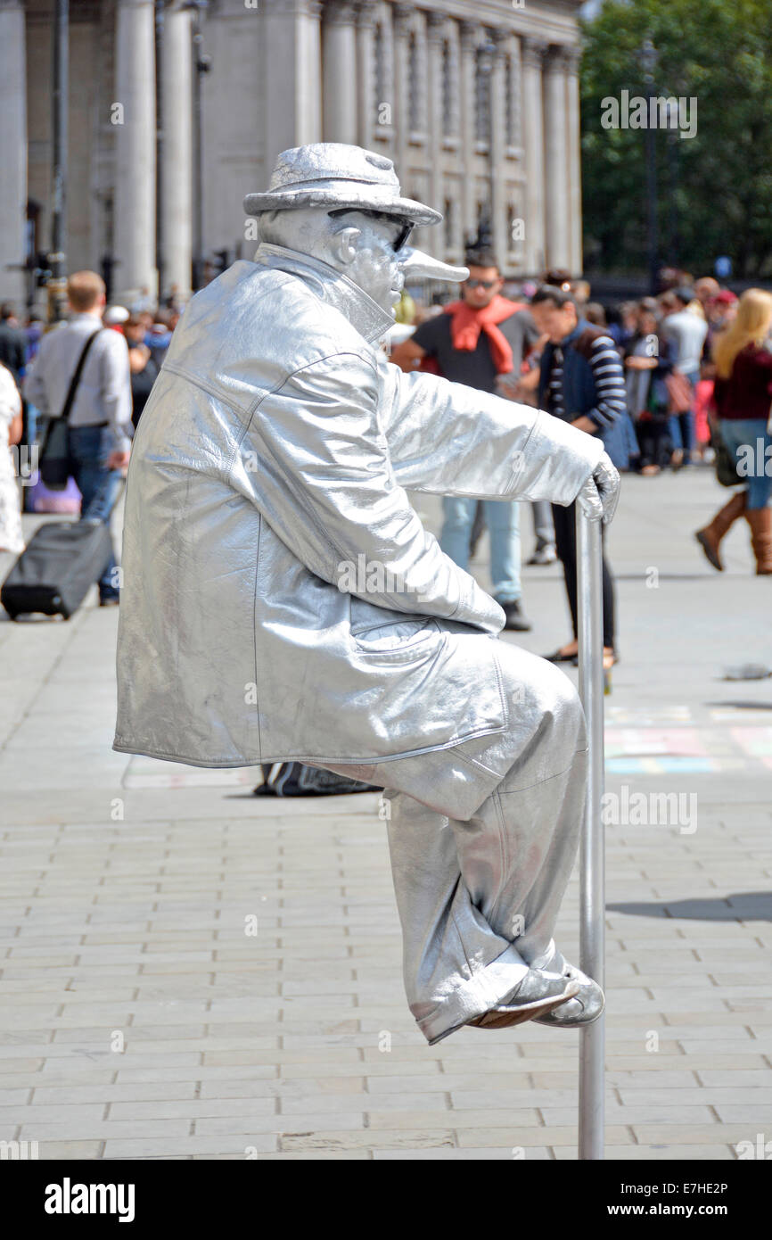 Lebende Straßenkünstlerin Person, die noch als Statue in Make-up & Kostüm sitzt scheinbar unsichtbare Unterstützung oder optische Illusion im Trafalgar Square London UK Stockfoto
