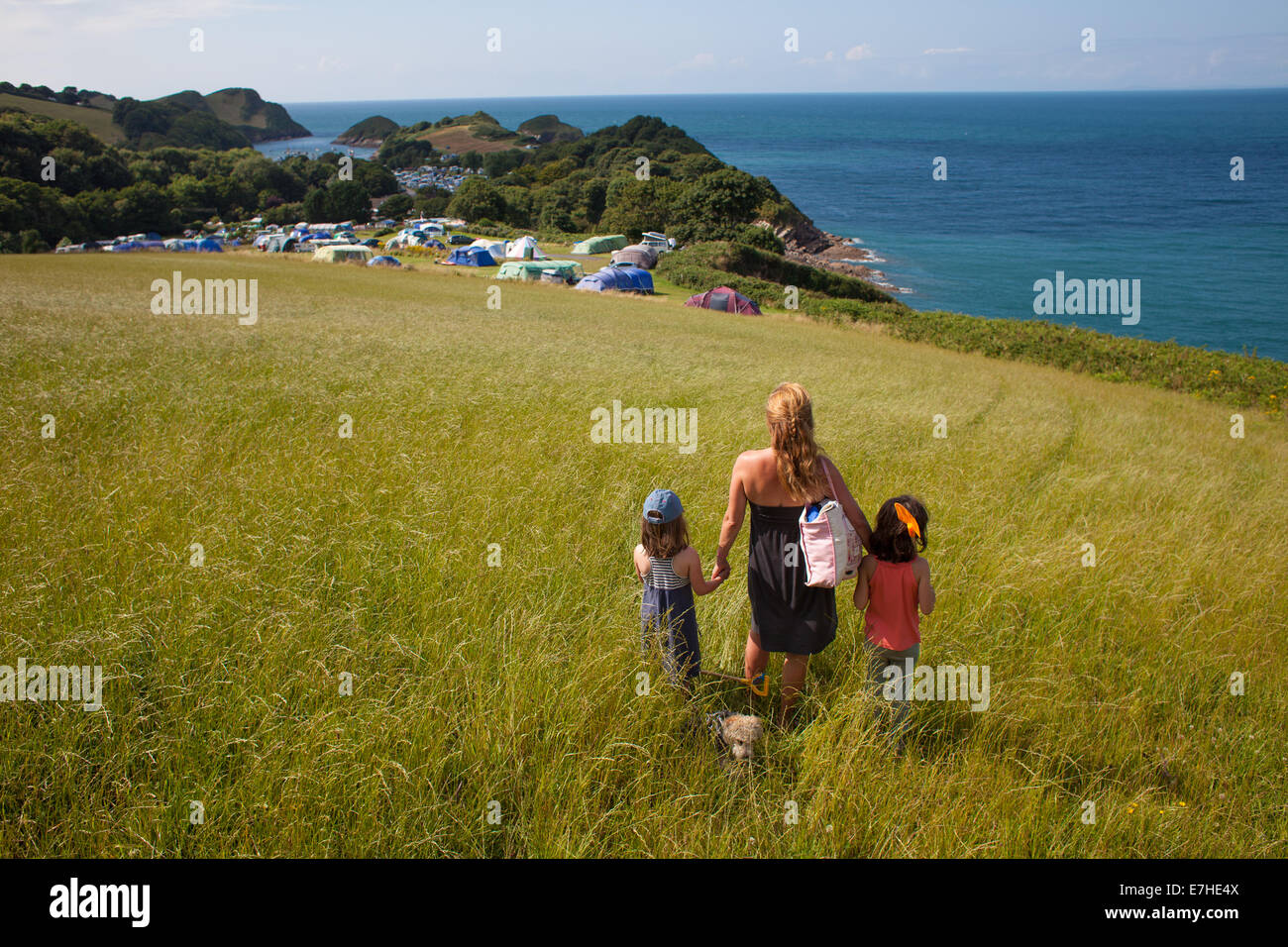 Eine Familie Look über eine saftige Wiese und Campingplatz über das Meer hinaus. Urlaub in Nord-Devon Stockfoto