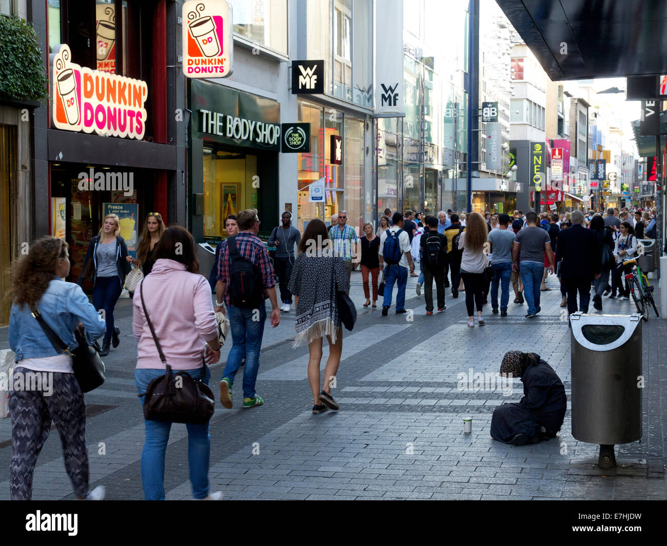 Belebten Haupteinkaufsstraße in Köln mit vielen Peoplepassing und Frau betteln um Geld Stockfoto
