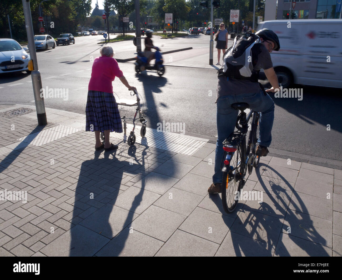 Alte Dame mit Walker, die darauf warten, überqueren Sie die Straße in Köln, NRW, Deutschland Stockfoto