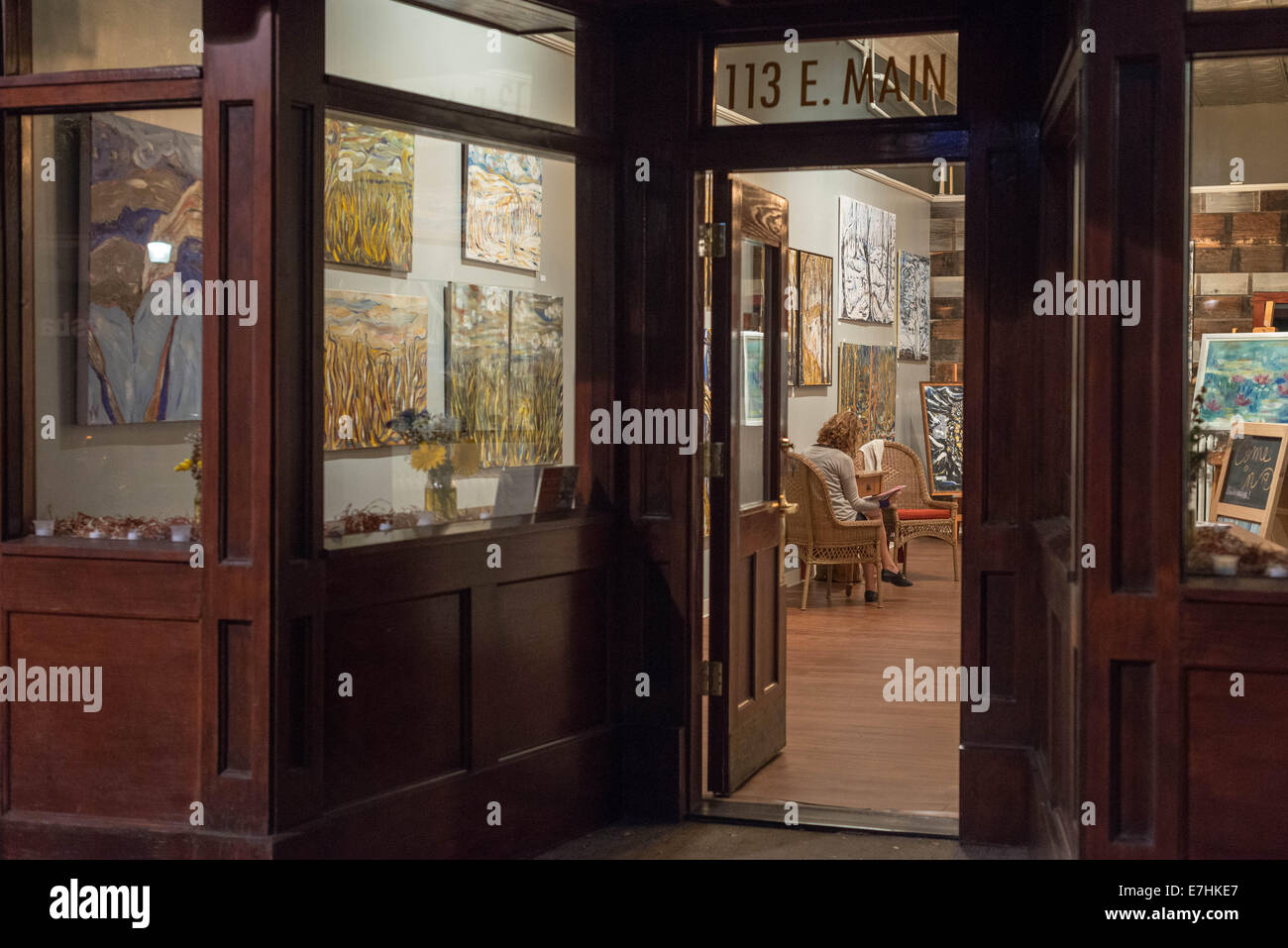 Eine Frau sitzt alleine in der Nähe von Feierabend in einer Innenstadt Galerie Mittwochabend, 17. September 2014, in Bozeman, Mont., USA. Offene Türen in der Nacht in Montana schließt sich bald als Sommer endet und der Herbst beginnt. Stockfoto