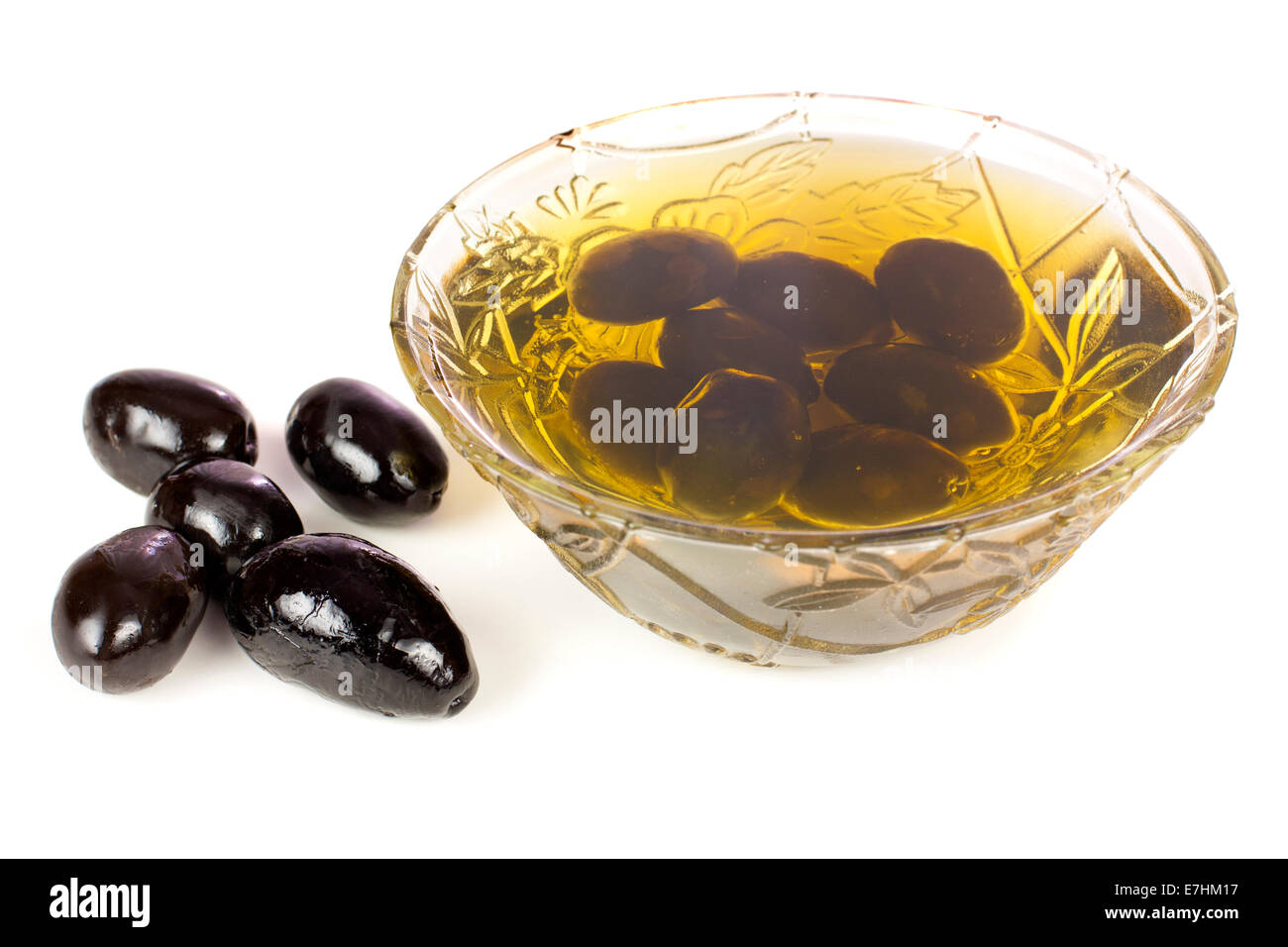 Schale mit schwarzen Oliven und Öl isoliert auf weißem Hintergrund Stockfoto