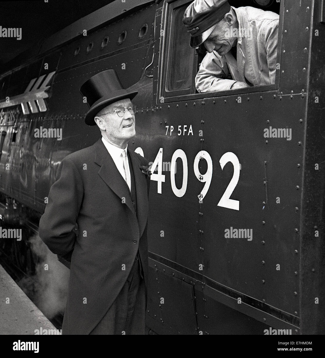 1950er Jahre historische, spricht ein Lokführer in Kabine mit der Maitre D' von der pullman-Wagen auf der Plattform an der Paddington Station. Stockfoto