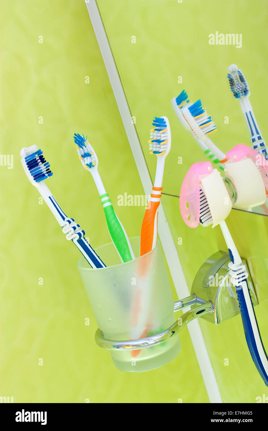 Bunte Zahnbürsten in einem Glas im Bad Stockfoto