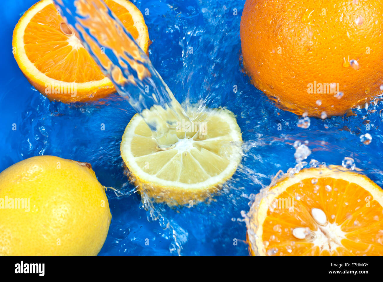 Frischen Wassertropfen auf Orangen und Zitronen und blauem Hintergrund Stockfoto