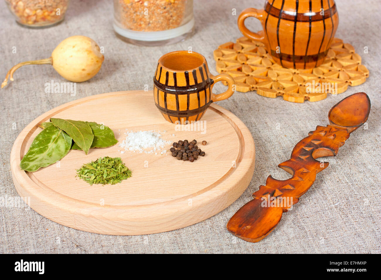 Verschiedene Zutaten wie Bay, Salz und Pfeffer auf einem Holzteller Stockfoto