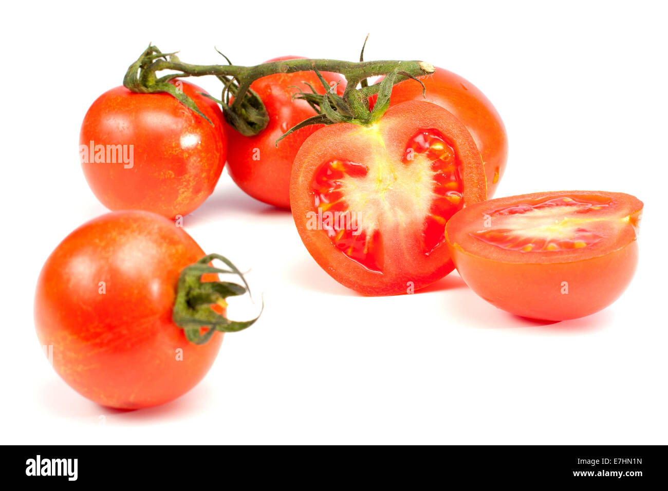 4 Tomaten und eine halbierte isoliert auf weißem Hintergrund Stockfoto