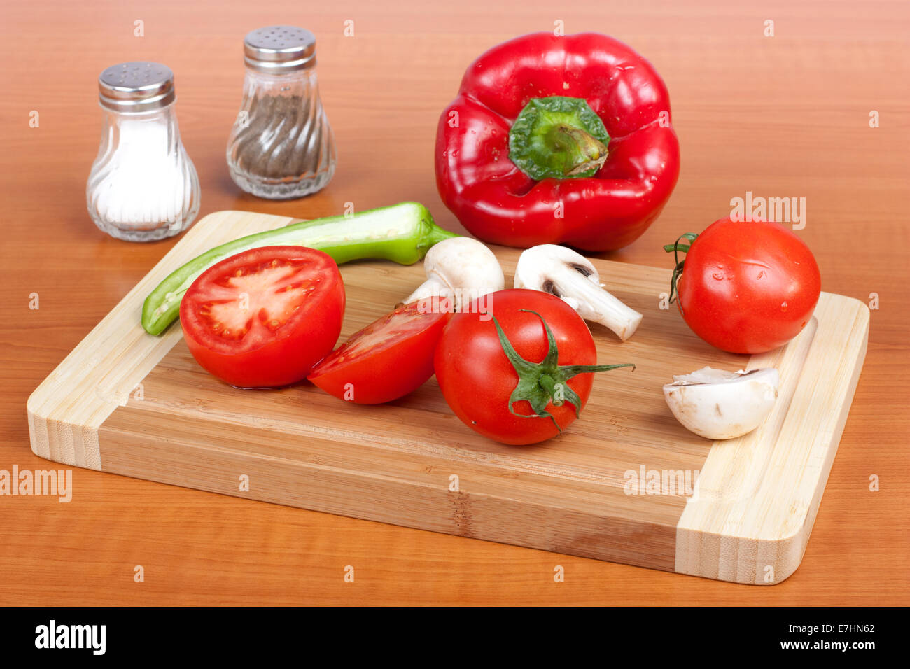 Frisches Gemüse zu allen Jahreszeiten auf Schneidebrett in Küche Stockfoto