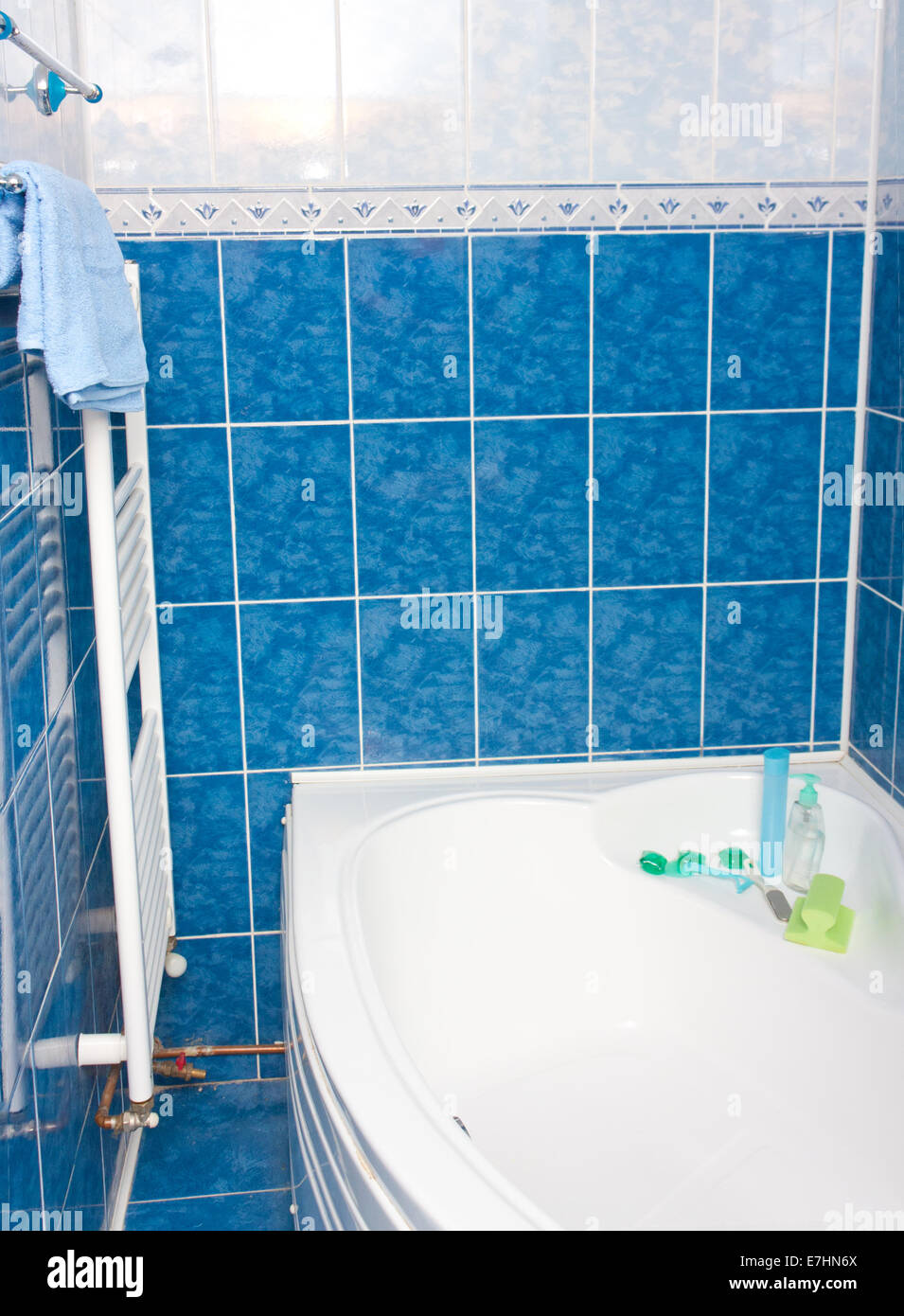 Modernes Bad mit blauen Kacheln, Badewanne und Heizkörper Stockfoto