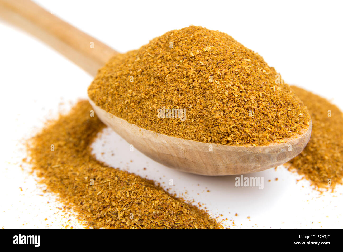 Curry-Pulver auf Holzlöffel auf weißem Hintergrund Stockfoto