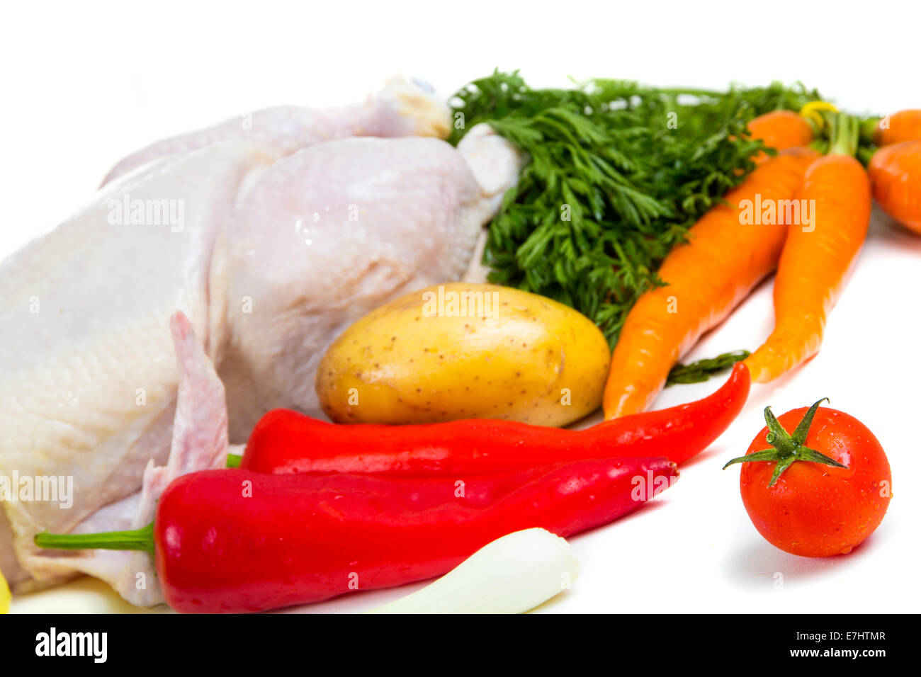 Cherry-Tomaten und ein Huhn mit Gemüse im Hintergrund Stockfoto