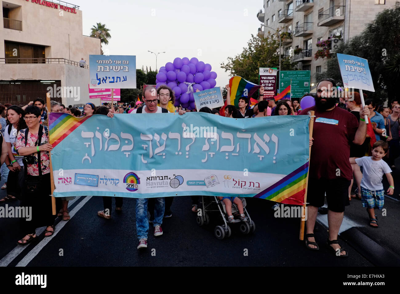 Israelis halten während der jährlichen Pride Parade ein Plakat mit einem biblischen Zitat mit der Aufschrift „Du sollst deinen Nächsten lieben wie dich selbst“. Israel Stockfoto