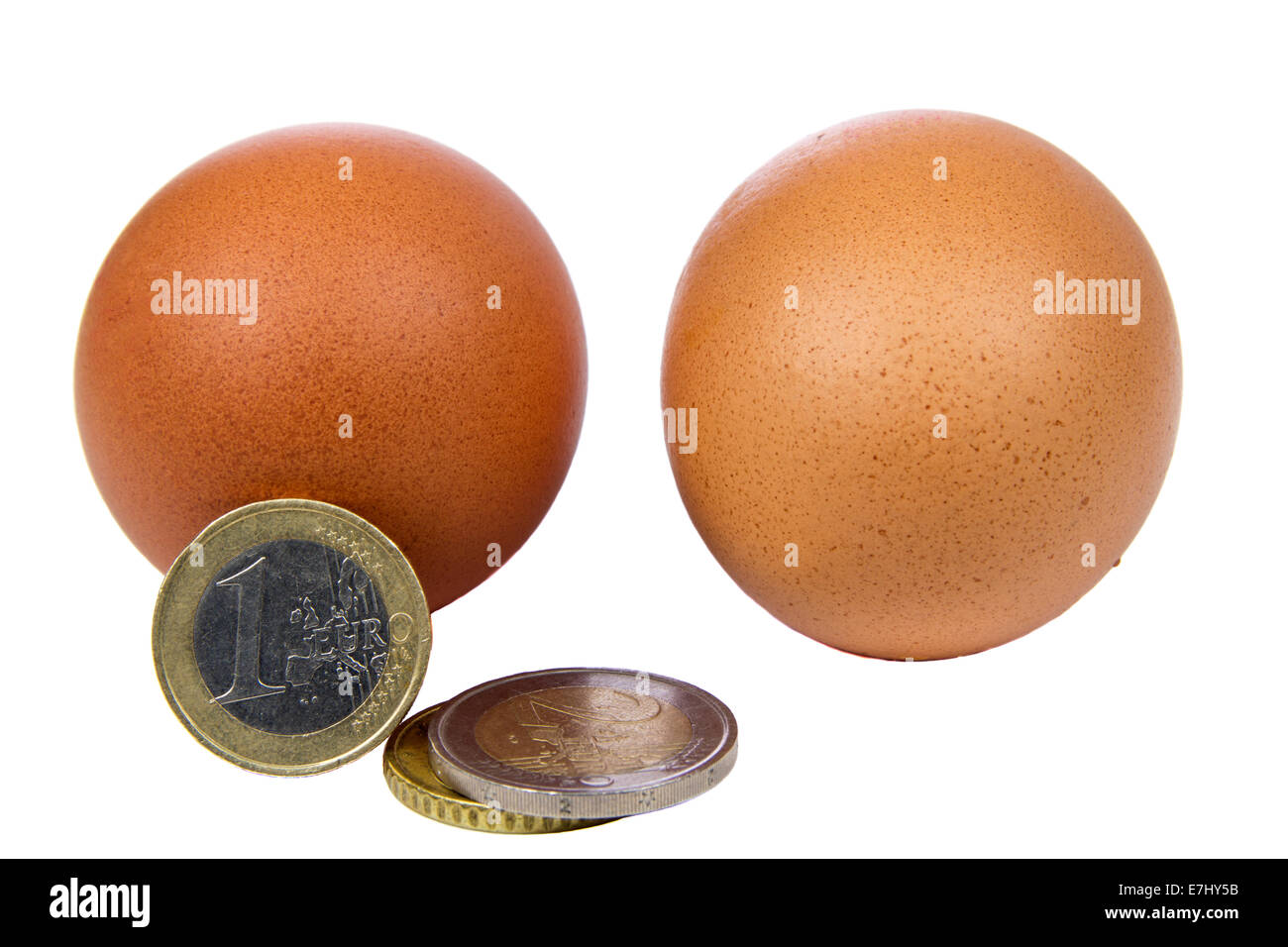Münzen und Eiern isoliert auf weißem Hintergrund Stockfoto