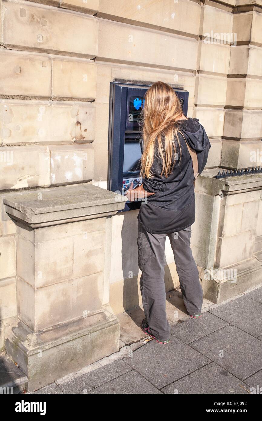 Eine Frau mit einem Barclays-Geldautomaten in Alnwick Northumberland UK Stockfoto