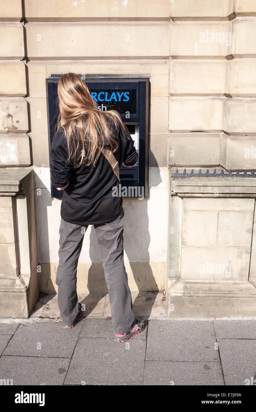 Eine Frau mit einem Barclays-Geldautomaten in Alnwick Northumberland UK Stockfoto