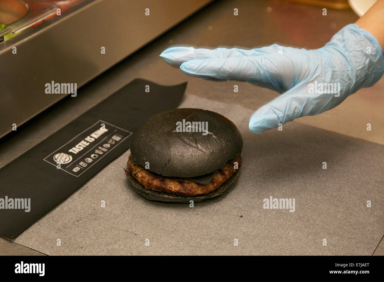 Tokio, Japan. 19. Sep, 2014. Eine Frau bereitet einen 'Kuro Burger' oder'schwarze Burger"Burger King Restaurant am 19. September 2014 in Tokio, Japan. Burger King startet seine Menü zwei Arten von schwarzen Burger "Kuro Diamant" und "Kuro-Perle", die schwarzen Brötchen und schwarzen Käse aus Bambus Holzkohle enthält, Knoblauch-Sauce mit Tintenfisch Tinte und Rindfleisch Frikadellen gemacht mit schwarzem Pfeffer ganz in schwarzer Farbe beginnt am Freitag, den 19. September zeitlich begrenzen gemacht. Bildnachweis: Aflo Co. Ltd./Alamy Live-Nachrichten Stockfoto