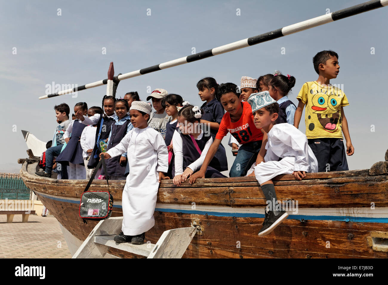 Gruppe der omanischen Schulkinder spielen auf einem alten Dhau-Schiff, Dhow-Museum, Sur, Ash Sharqiyah Provinz, Sultanat von Oman Stockfoto