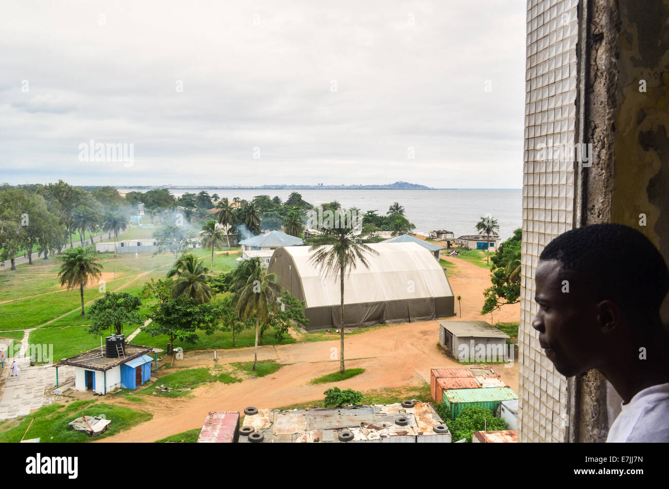 Afrikanischer Mann in einem Hangar und Base Camp von einem UN-Lager in Monrovia, Liberia, von der Spitze der Ruinen von Hotel Africa Stockfoto