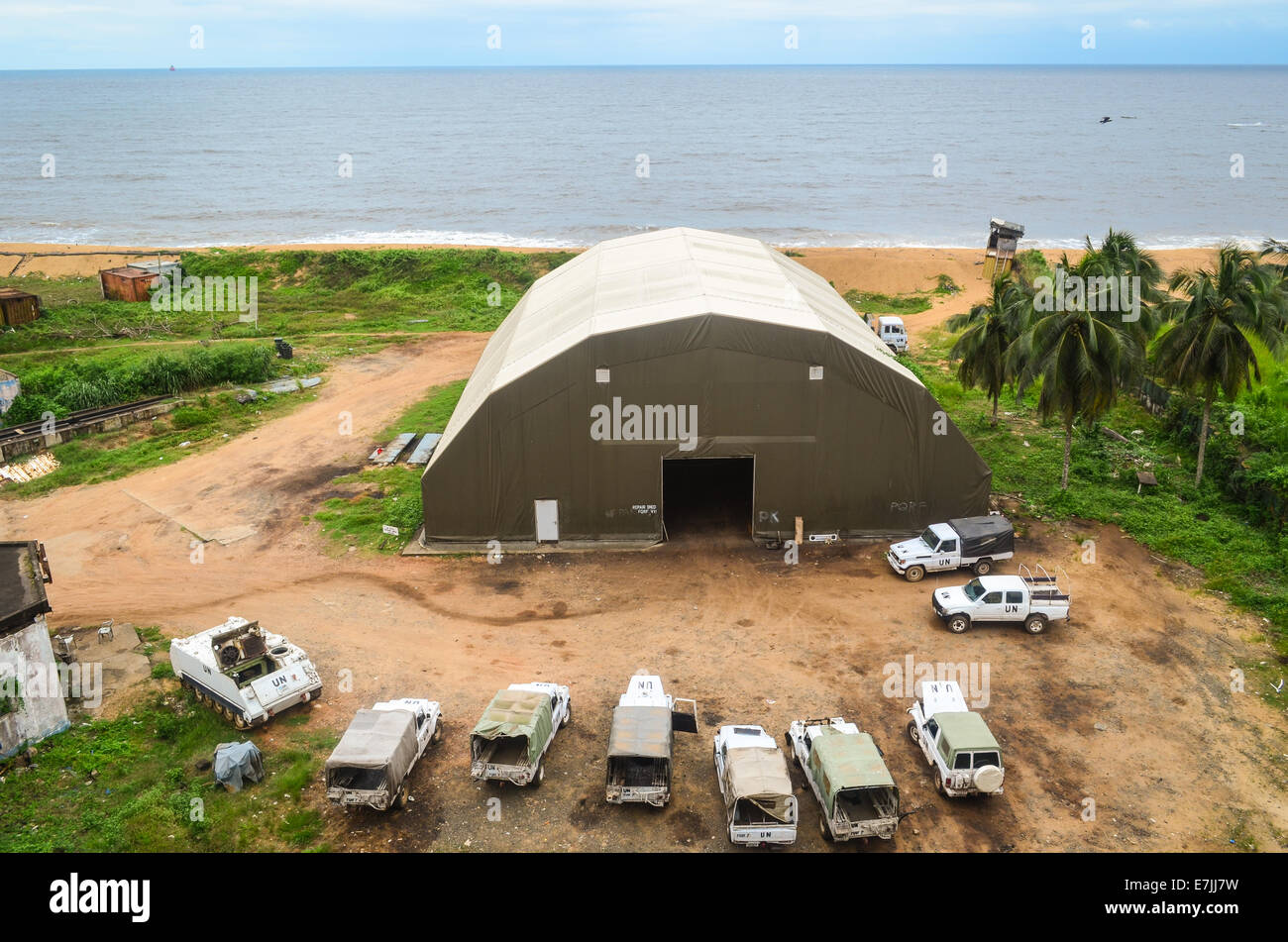 Fahrzeuge und Hangar einer UN-Camp in Monrovia, Liberia, gesehen von der Spitze der Ruinen von Hotel Afrika Stockfoto