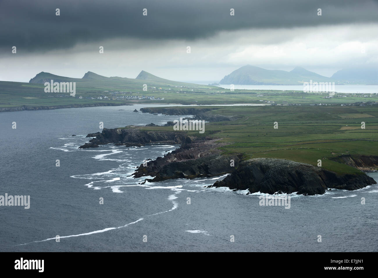 Dunkle Wolken ragen über Ballyferriter Bucht und den Gipfeln der drei Schwestern auf der Dingle Halbinsel, Irland. Stockfoto