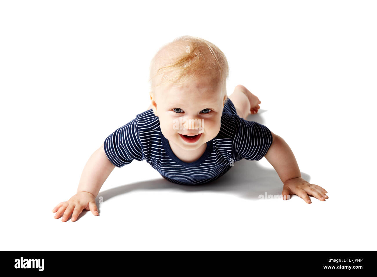 Glückliches Baby liegt auf weißen Boden. Isoliert auf weißem Hintergrund. Stockfoto