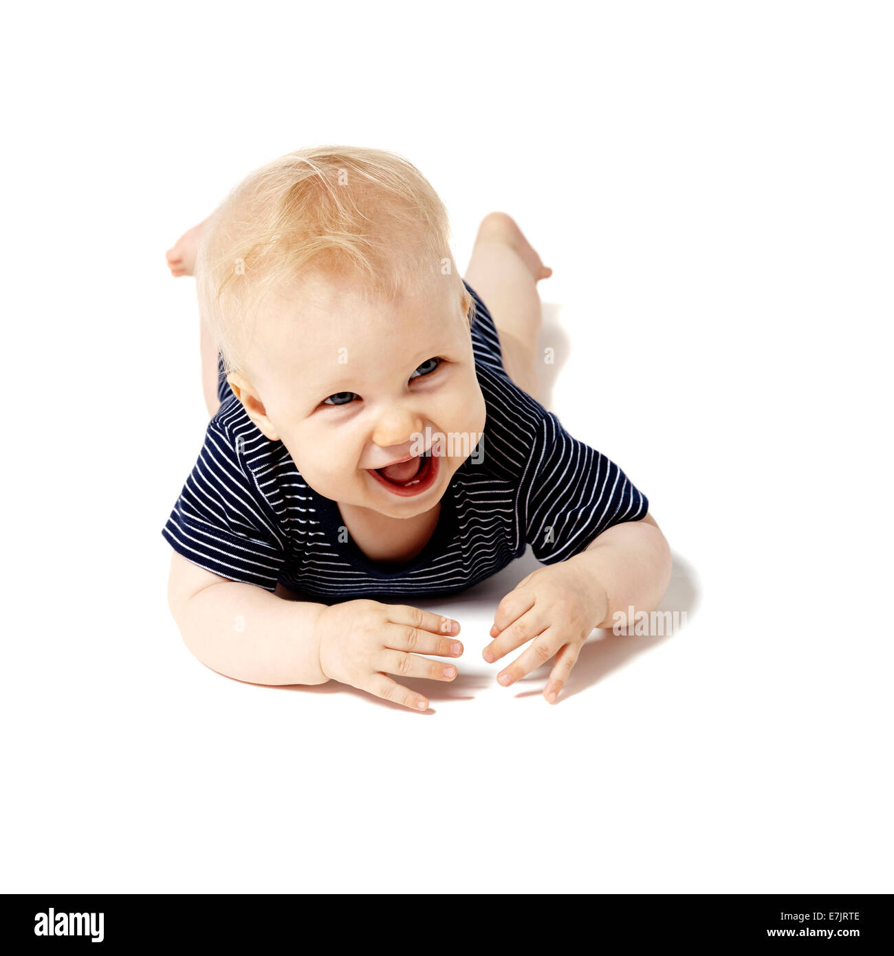 Glückliche sieben Monate altes Baby am Boden liegend. Studio gedreht. isoliert auf weißem Hintergrund. Stockfoto