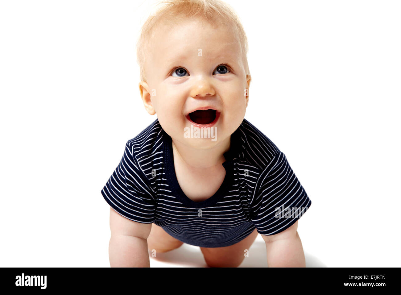Glückliches Baby auf weißen Boden kriechen und nach oben schauen. Stockfoto