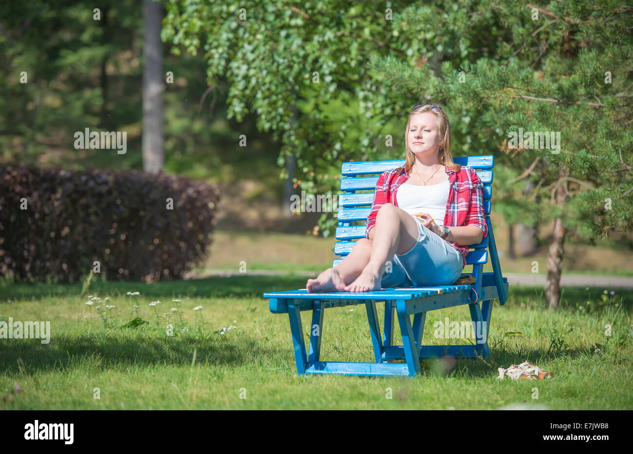 Junge schöne Frau, die Bräunung auf der Sonnenliege Stockfoto