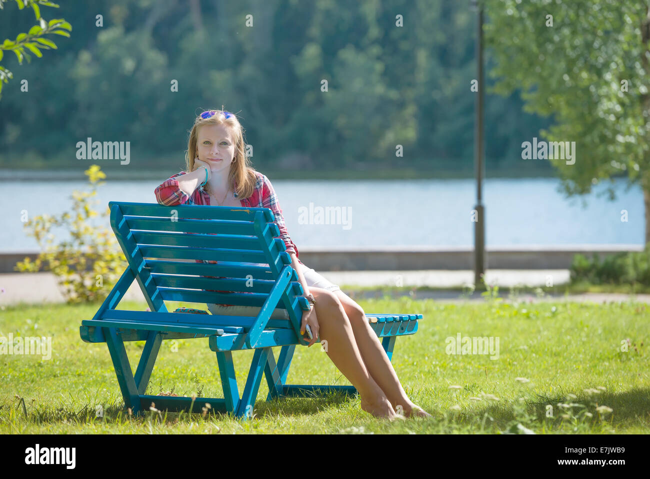 Junge schöne Frau, die Bräunung auf der Sonnenliege Stockfoto