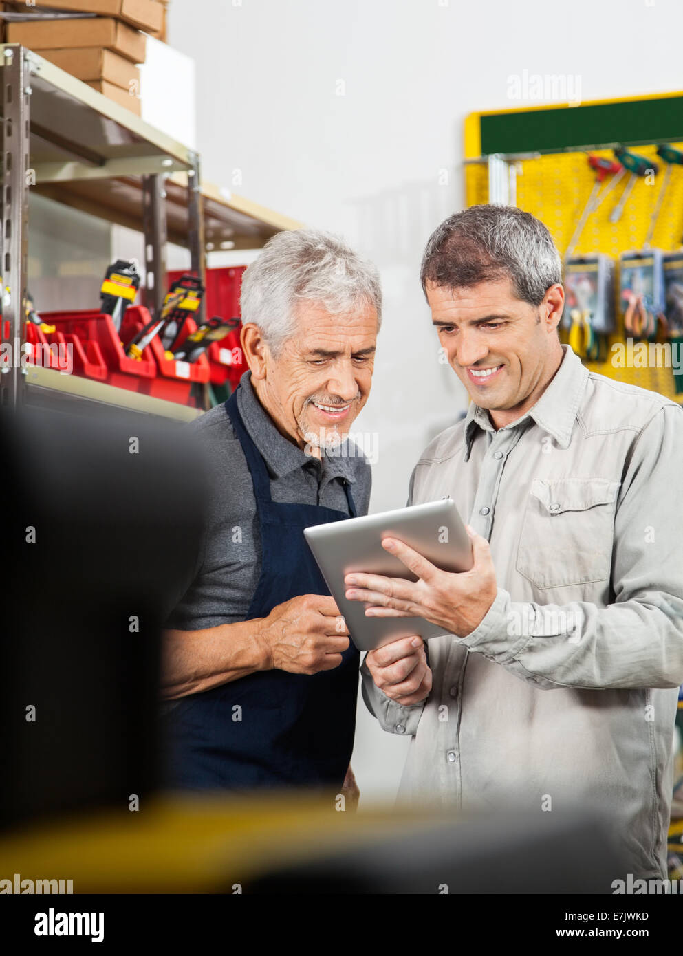Verkäufer und Kunde mit Hilfe digitaler Tablet Stockfoto