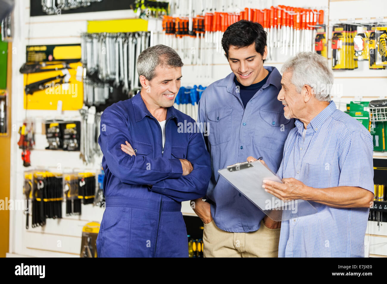 Arbeitnehmer, die betrachten Kunden mit Zwischenablage im Hardware-Geschäft Stockfoto