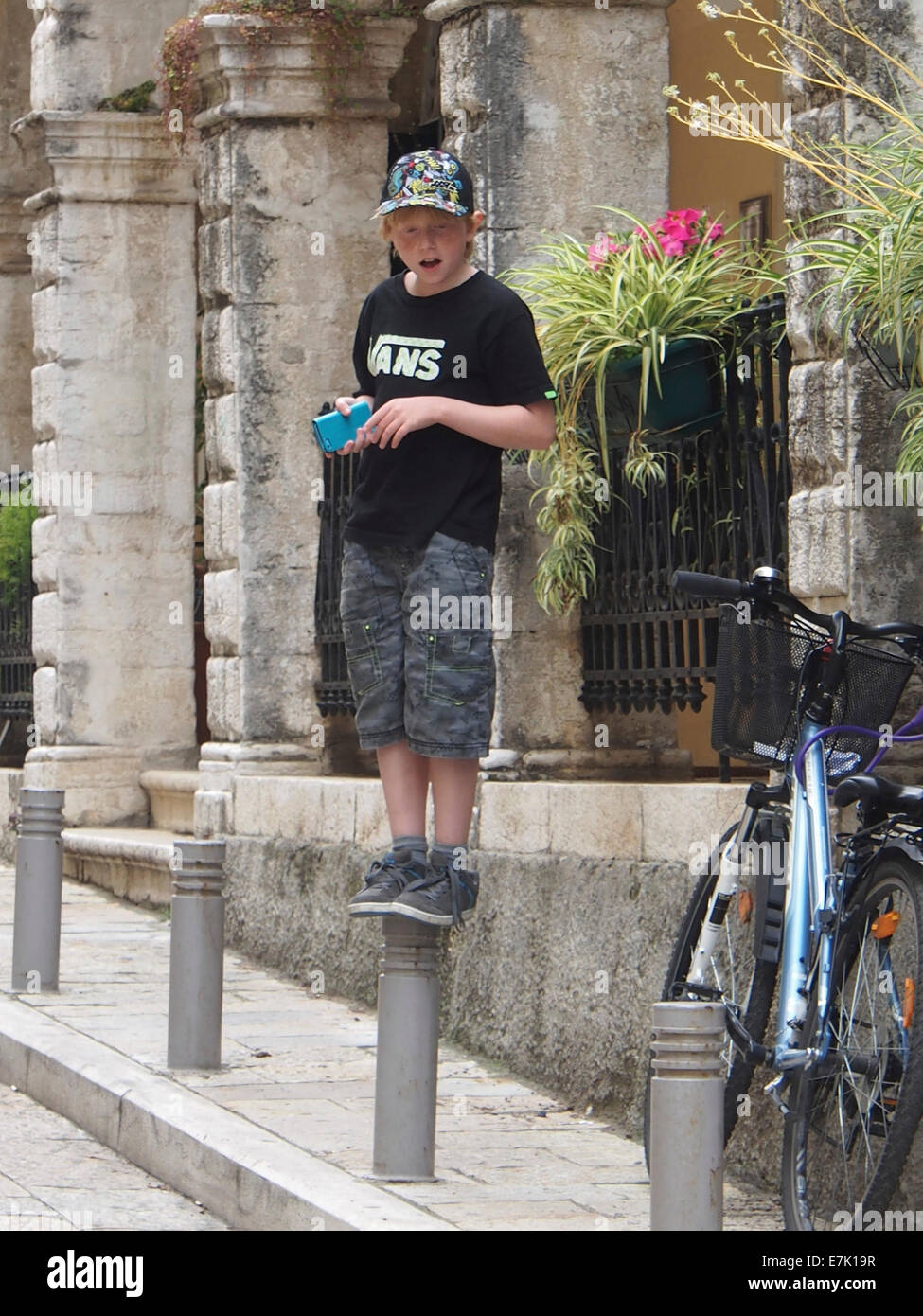kleiner Junge stand auf einem Mast mit einer base Ball-Mütze Stockfoto