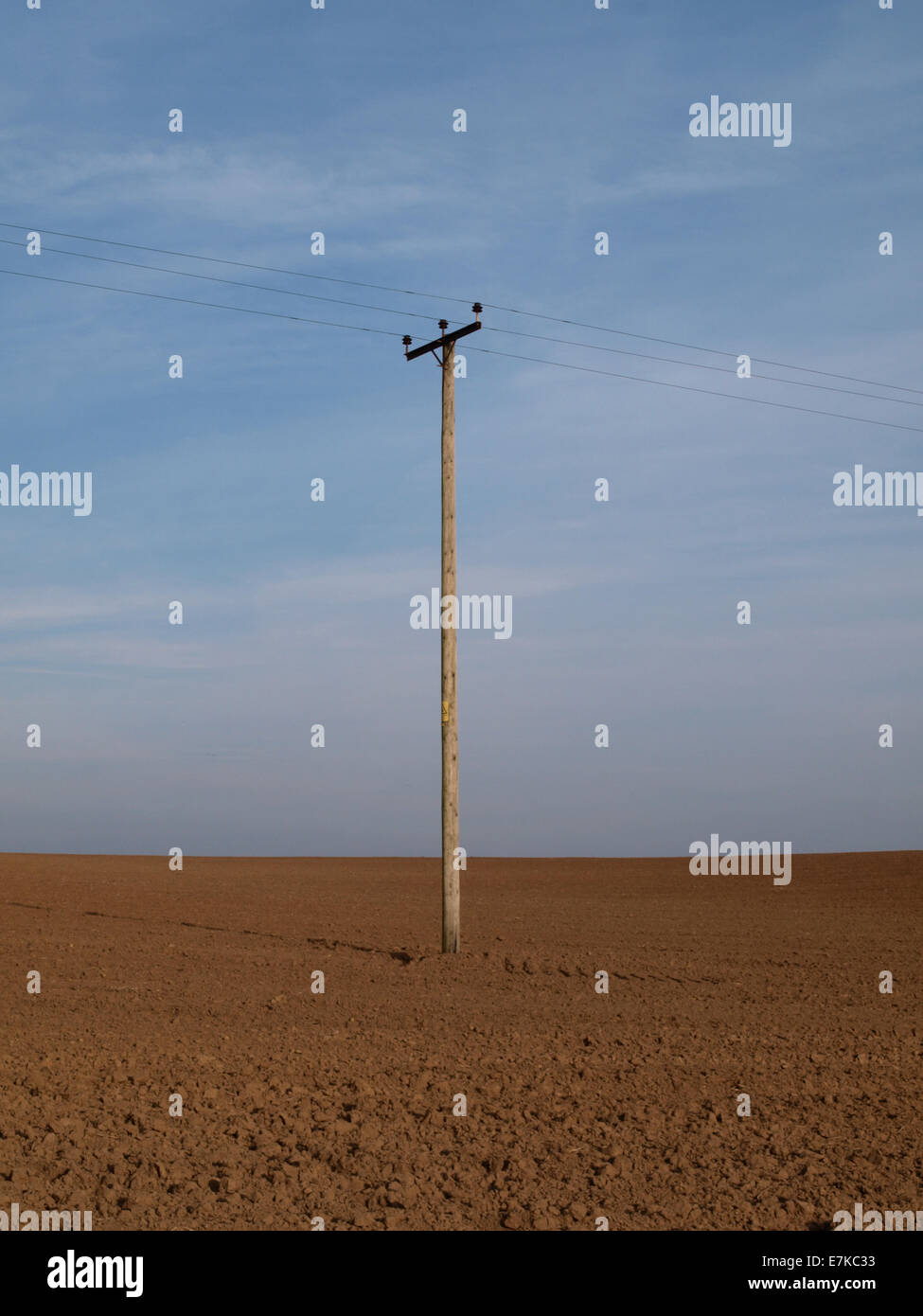 Telegrafenmast mitten auf einem gepflügten Feld, UK Stockfoto