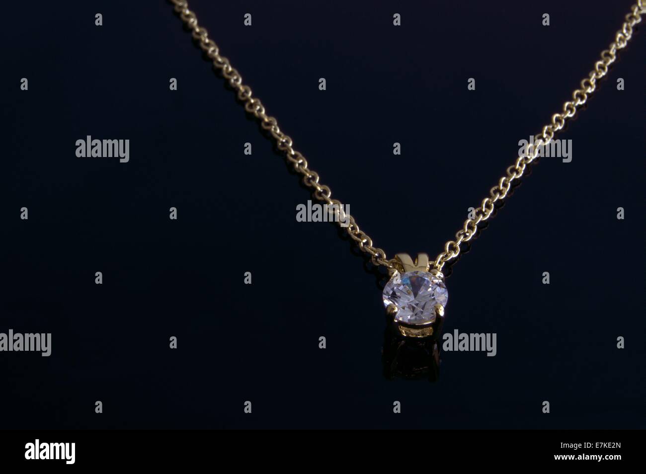Gold Diamant Solitär-Halskette auf schwarzem Hintergrund. Stockfoto