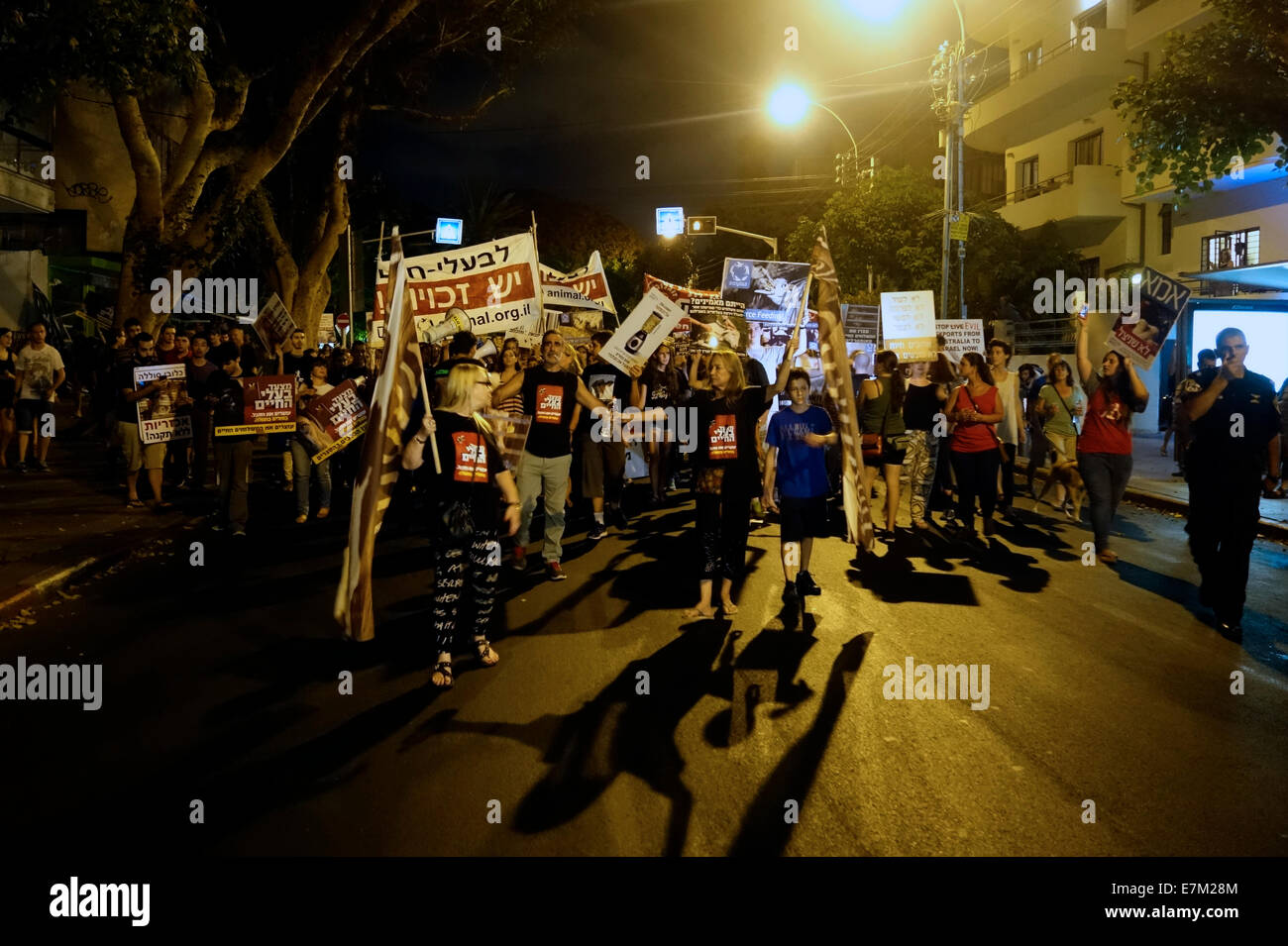 Menschen, die Plakate halten, die gegen die erlaubte Einschließung von Tieren protestieren Wird in Forschungslabors und in der Fabriklandwirtschaft verwendet, während sie während des marsches Eine Kundgebung für Tierrechte in Tel Aviv, Israel Stockfoto