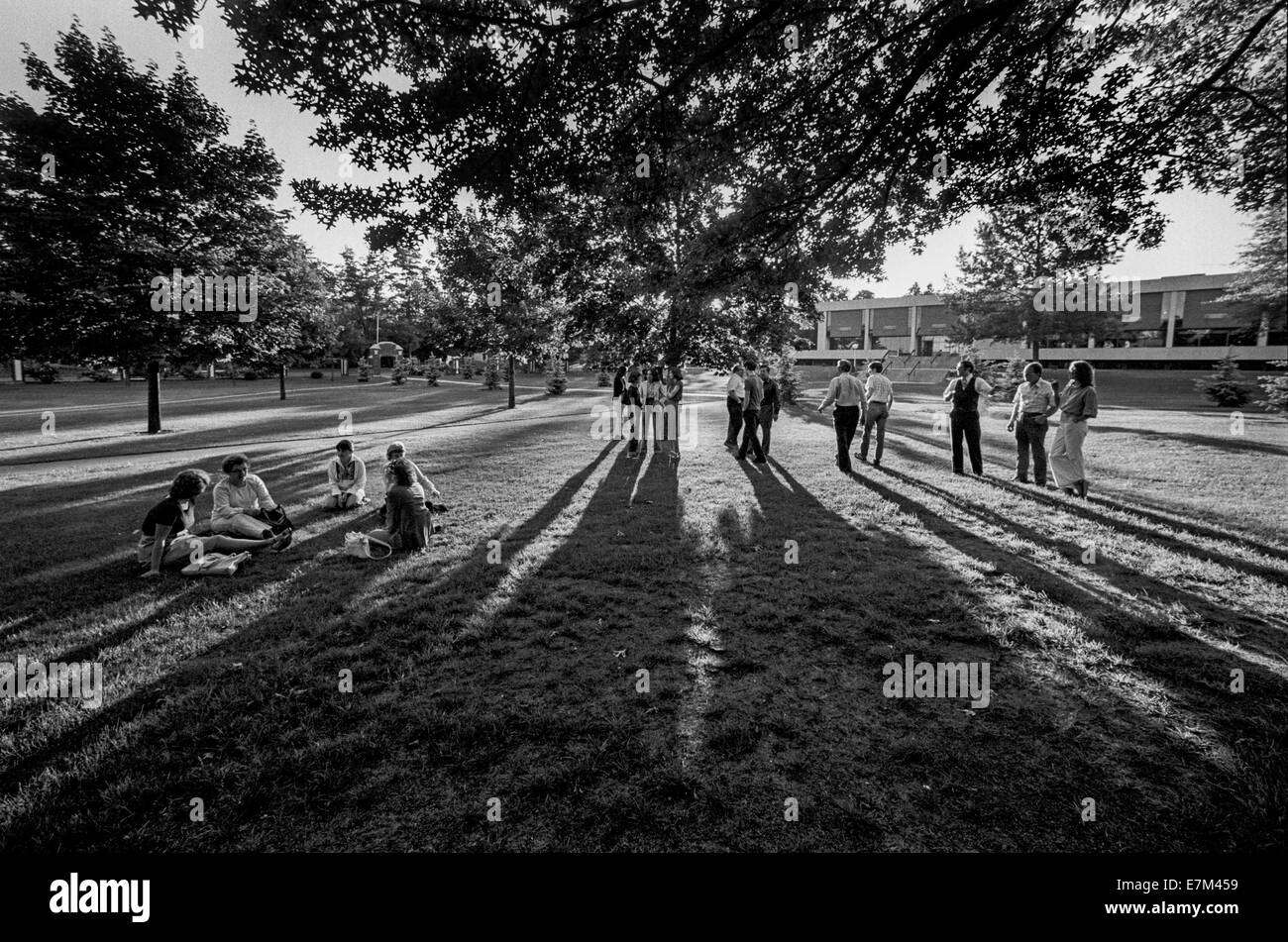 College-Studenten werfen lange Schatten, während sie darauf in der Abendsonne für ihre Klassen auf dem Campus der Framingham State College in Massachusetts warten. Stockfoto